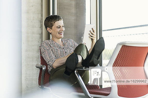 Happy businesswoman using tablet in office