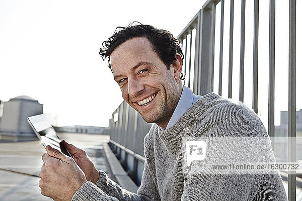 Porträt eines lächelnden Mannes mit Tablet-Computer