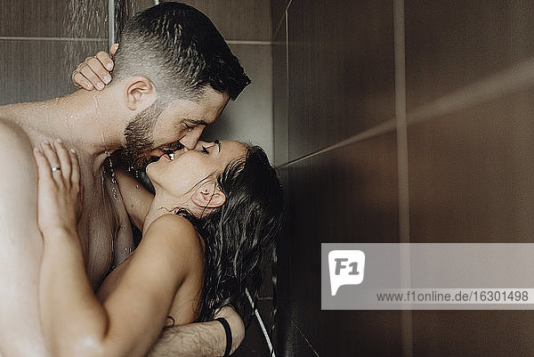 Nacktes romantisches Paar küsst sich auf die Lippen im Badezimmer