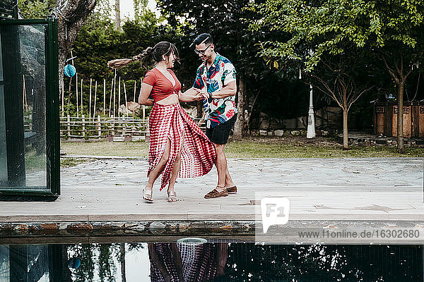 Mann und Frau tanzen am Pool