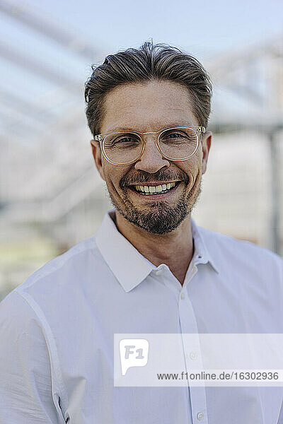 Close-up of smiling male professional wearing eyeglasses in plant nursery