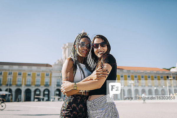 Women embracing each other at Praca Do Comercio against clear sky  Lisbon  Portugal