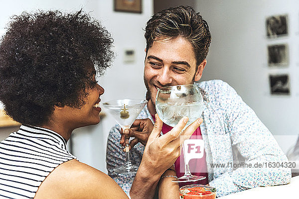 Nahaufnahme eines glücklichen Paares  das sich beim Trinken von Cocktails in einer Bar ansieht