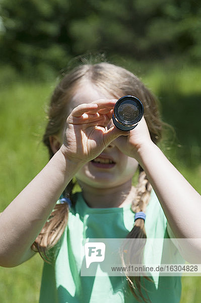 Germany  Bavaria  girl looking through binoculars  close-up