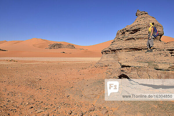 Algerien  Sahara  Tassili N'Ajjer National Park  Frau steht auf Felsen in Tin Merzouga