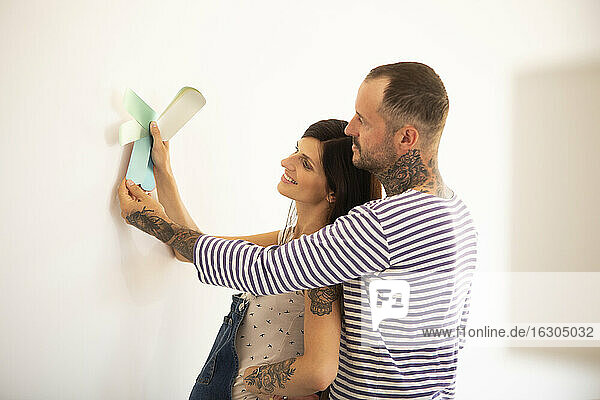 Ehepaar wählt Farbmuster für die Wand im neuen Haus aus