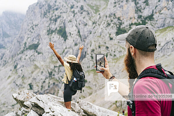 Mann fotografiert eine Frau auf einem Berggipfel an der Ruta Del Cares  Asturien  Spanien