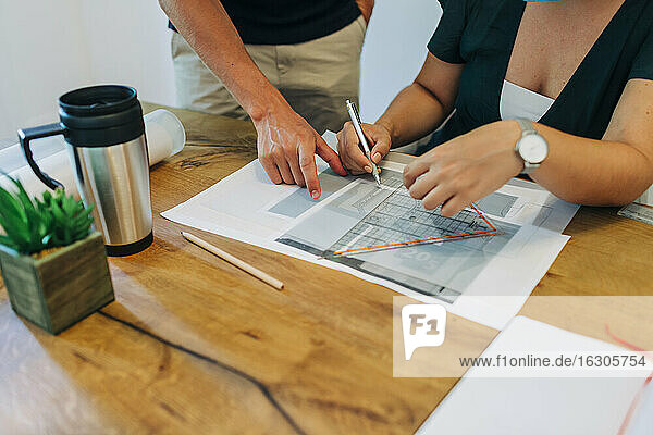 Geschäftskollegen diskutieren über Design am Schreibtisch im Büro