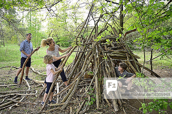 Familie baut Lager mit Baumstamm im Wald