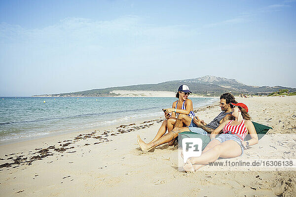Männliche und weibliche Freunde entspannen sich im Urlaub am Strand  Tarifa  Spanien