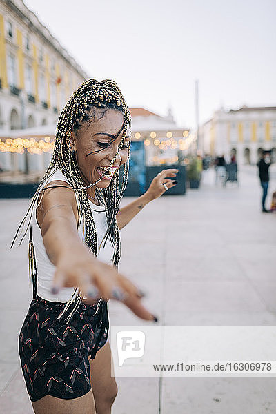 Fröhliche Touristin tanzt auf dem berühmten Stadtplatz  Praca Do Comercio  Lissabon  Portugal