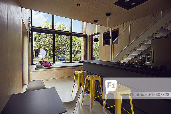 Empty yellow stools by kitchen counter in tiny house