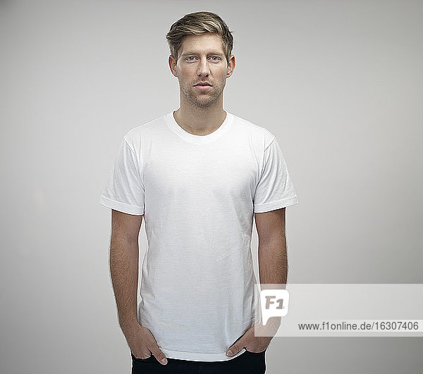 Portrait of young man with hands in his pockets wearing white t-shirt