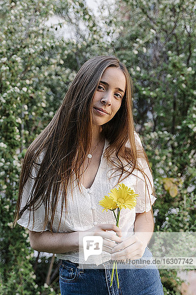 Junge Frau hält gelbe Blumen im Frühling
