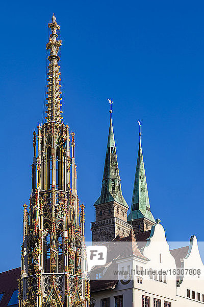 Germany  Bavaria  Nuremberg  Schoner Brunnen fountains with towers of Saint Sebaldus Church in background