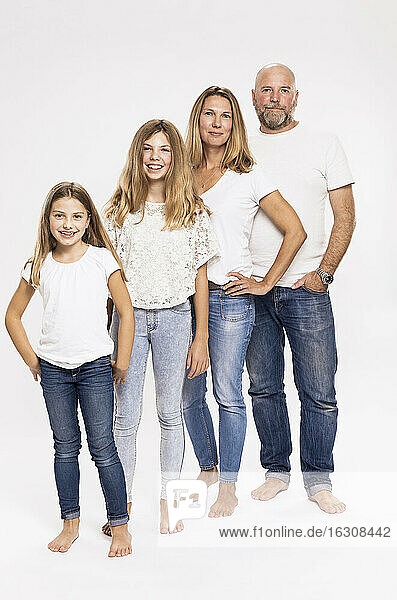 Eltern mit Töchtern stehend vor weißem Hintergrund