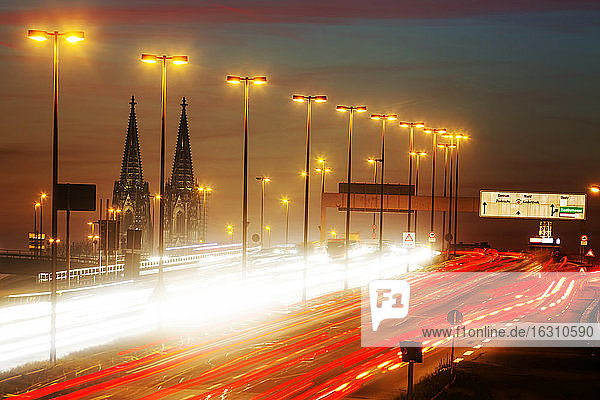 Deutschland  Nordrhein-Westfalen  Kölner Dom und Straßenverkehr auf der beleuchteten Zoobrücke in der Abenddämmerung