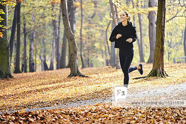 Junge Frau joggt im Herbstwald
