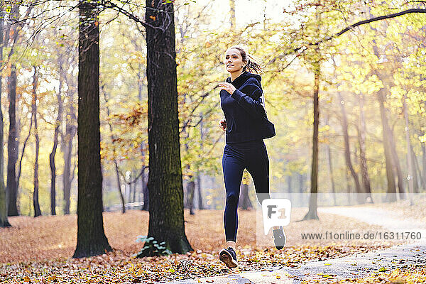Junge Frau joggt im Herbstwald