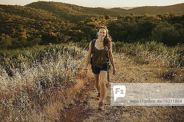 Abenteuerliche Frau  die bei Sonnenuntergang im Wald spazieren geht