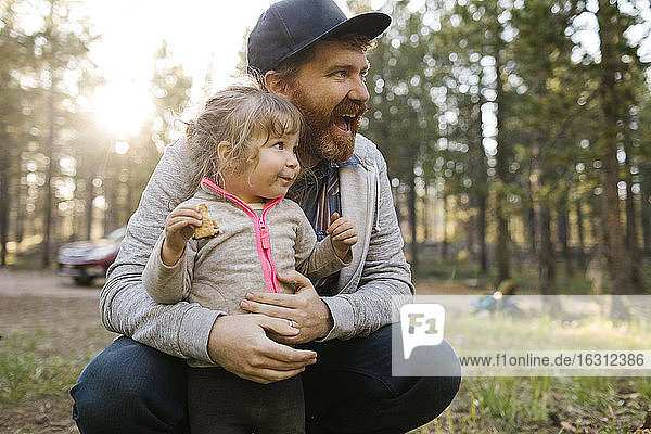 Smiling man with daughter (2-3) on laps in forest  Wasatch Cache National Forest