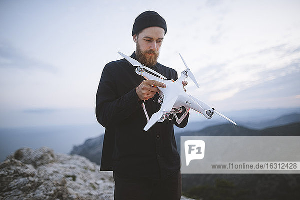 Italien  Ligurien  La Spezia  Mann auf Berggipfel mit Drohne