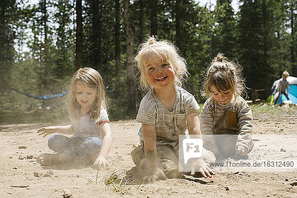 Drei lächelnde Mädchen (2-3  4-5) spielen im Sand auf dem Campingplatz  Wasatch-Cache National Forest