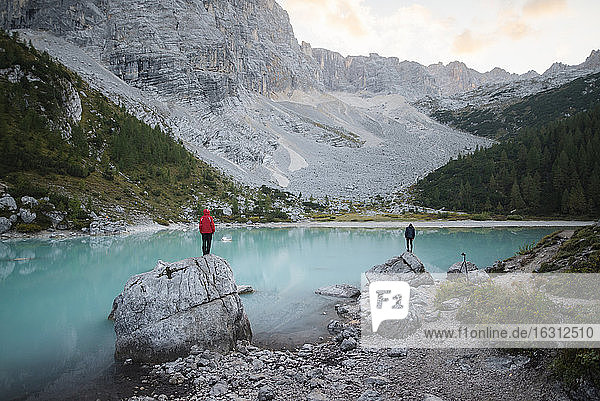 Italy  South Tyrol  Cortina d Ampezzo  lake Sorapis  Men standing on top of rock formations looking at view