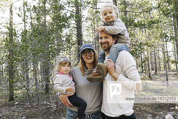 Portrait of happy parents carrying little daughters (2-3) in Uinta-Wasatch-Cache National Forest