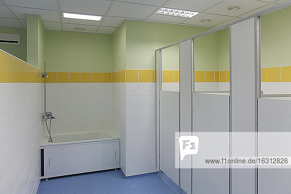 Schultoiletten  gelbe Lackierung und weiße Türen  blauer Fußboden
