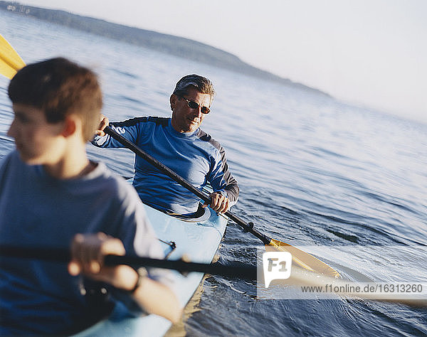 Father and son paddling sea kayak