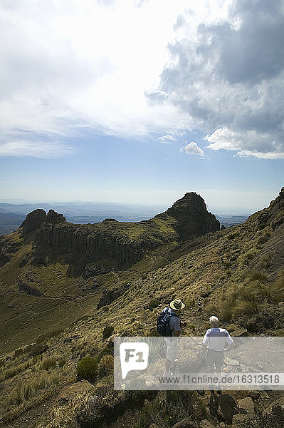 Hikers looking at mountain peaks in the Drakensberg Mountains  South Africa.