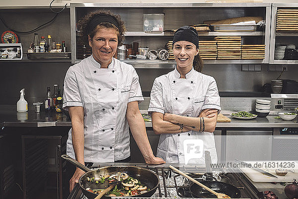 Portrait of smiling female chefs in commercial kitchen
