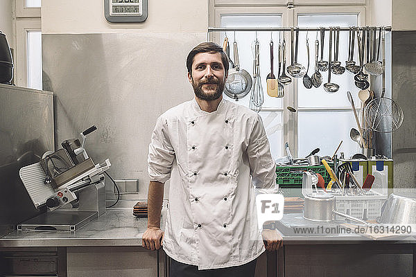 Portrait of confident chef standing in commercial kitchen