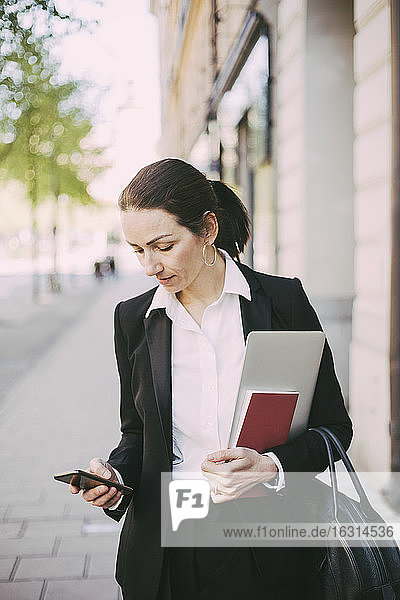 Geschäftsfrau benutzt Smartphone in der Stadt