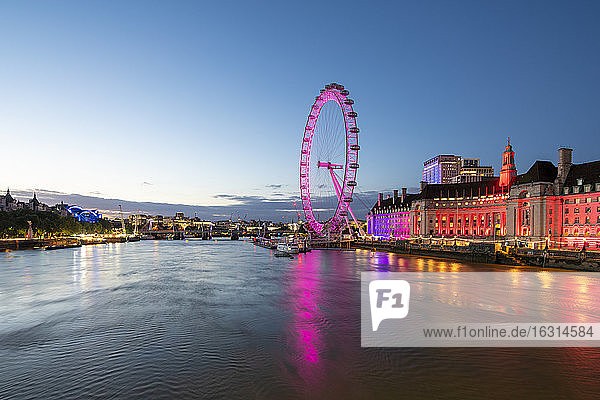 The London Eye lit up pink during blue hour  and River Thames  London  England  United Kingdom  Europe