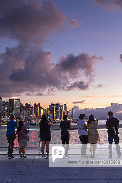 Menschen beobachten den Sonnenuntergang von Harbour City  Hongkong  China  Asien