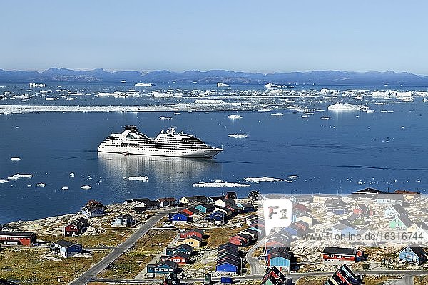 Bunte Häuser mit Blick in die Diskobucht zum Kreuzfahrtschiff Seabourn Quest  Ilulissat  Westgrönland  Grönland  Nordamerika