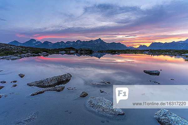 Brennender Himmel bei Sonnenuntergang auf Bergen  die sich im unberührten See spiegeln  Muottas Muragl  Engadin  Kanton Graubünden  Schweiz  Europa