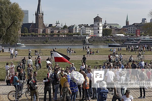 Demo gegen Corona-Regeln auf den Rheinwiesen  Mann mit verbotener Reichskriegsflagge  umringt von Menschen  Düsseldorf  Nordrhein-Westfalen  Deutschland  Europa
