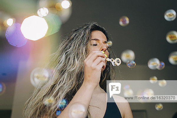 Junge Frau beim Blasen von Seifenblasen