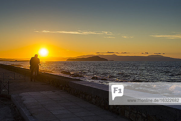 Griechenland  Kreta  Mann genießt den Sonnenuntergang in Chania
