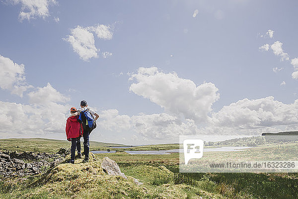 Rückenansicht von zwei Brüdern mit Blick auf die Aussicht  Cairngorms  Schottland  UK