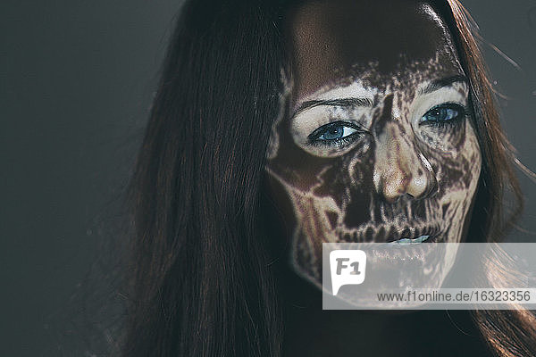 Woman with projected skull on her face