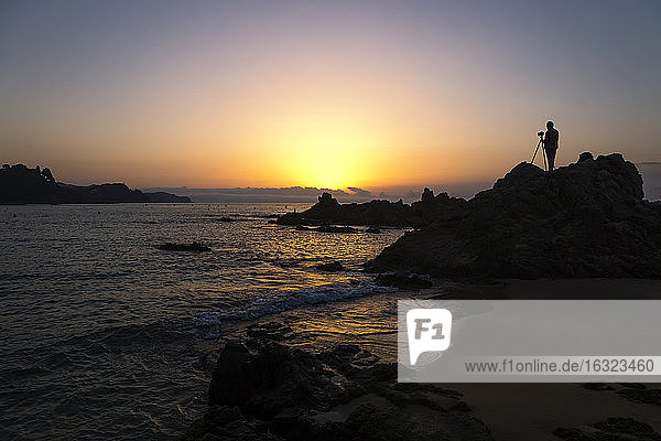 Spain  Catalonia  Lloret de Mar  Platja de Santa Christina  Silhouette of a photographer at sunrise