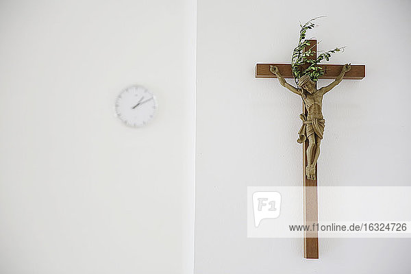 Kreuz und Uhr in einem Presbyterium