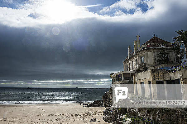 Portugal  Cascais  dramatisches Licht über dem Strand und einer alten Villa