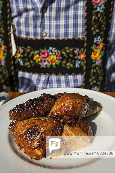 Deutschland  München  Oktoberfest  Mann mit halbem Huhn auf Teller