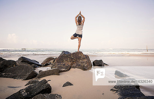 Sri Lanka  Kabalana  junge Frau übt Yoga am Strand