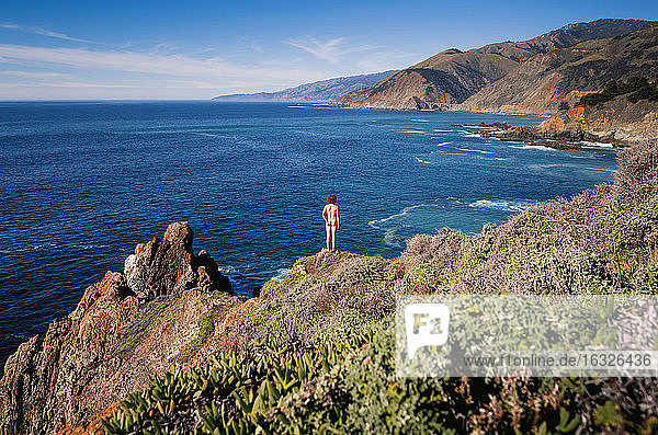 USA  Kalifornien  Big Sur  Küste  Rückansicht eines auf einem Felsen stehenden nackten Mannes